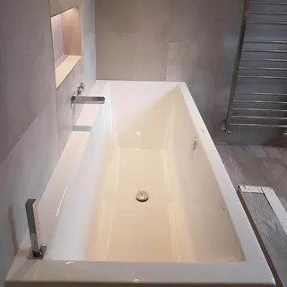 Freestanding bath installed beside patterned floor tiles