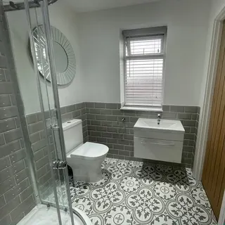 Finished bathroom with bath, basin and wall tiling