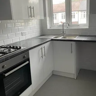 Finished kitchen with storage units and sink